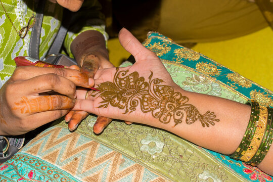 designing mehandi on hand
