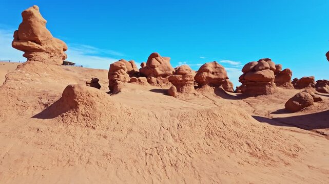 Unique mushroom-shaped sandstone hoodoos stand across the rugged desert badlands of Goblin Valley State Park in Utah