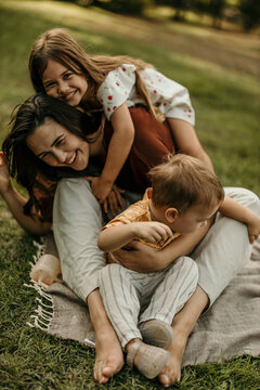 Mother and children bonding and playing in park