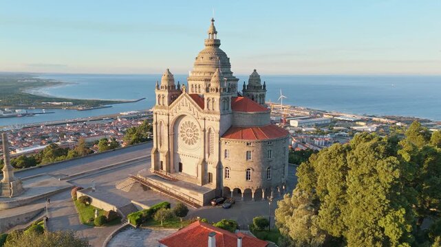 Sunrise drone view of the Sanctuary of Santa Luzia in Viana do Castelo, Portugal overlooking the city and ocean. Orbit parallax tilt shot