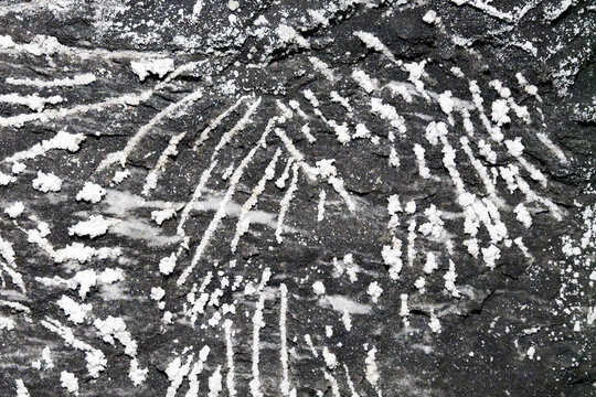 White Salt Mineral Formations on Dark Rock Surface Texture