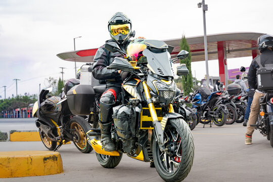 Motorcyclist in Full Gear Sitting on Bike at Gas Station