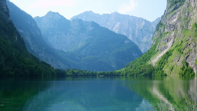 Obersee is a mountain lake located in the Alps of Bavaria, Germany. The video shows the clear waters and tall mountains surrounding the lake in a natural setting.