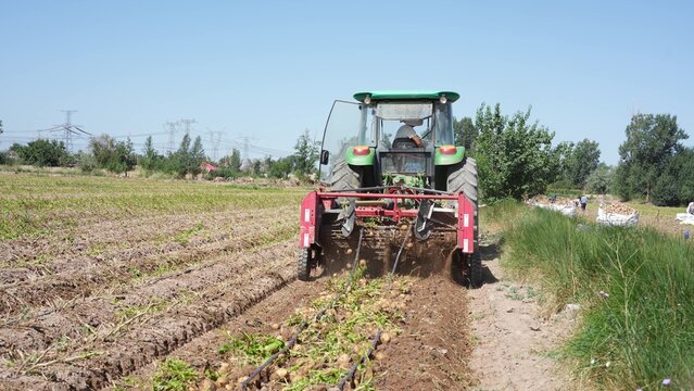 green tractor plowing field for farming