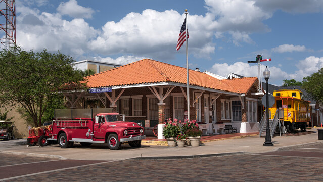 Historic train depot and vintage red fire truck parked by Plant Street in Winter Garden, Florida under a cloudy sky. April 5, 2025. 
