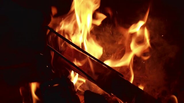 Enjoying the warmth of a fire in a backyard at night while sharing stories and cooking together with friends and family in fall weather