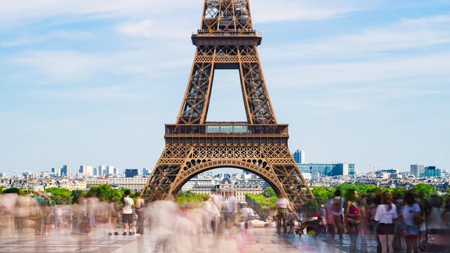 Eiffel Tower in Paris with many visitors during summer - City hotspot and Landmark in Time-lapse with moving clouds and blue sky at viewpoint Palais de Chaillot near Place du Trocad&eacute;ro, France 2026