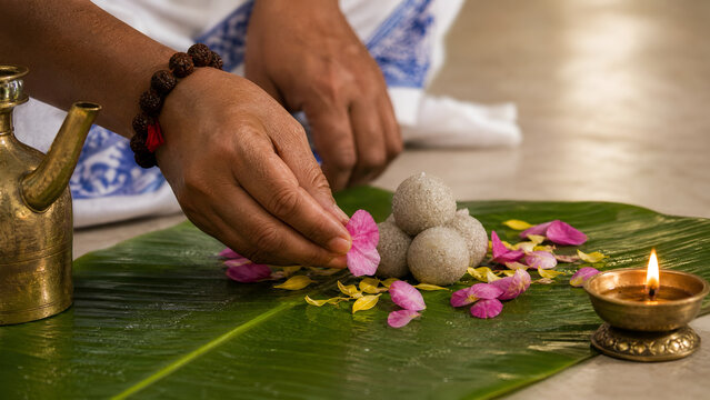 Hands offering flowers and rice balls during pitru paksha ritual