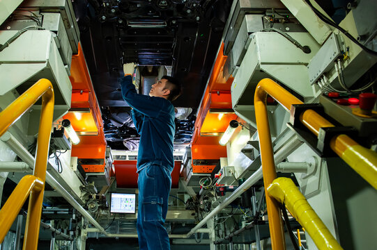 Auto Worker Inspecting Car Chassis