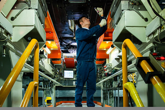Auto Worker Inspecting Car Chassis