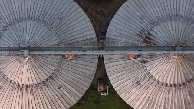 Top down aerial view of large circular industrial storage tanks and processing infrastructure at an industrial facility in southern France