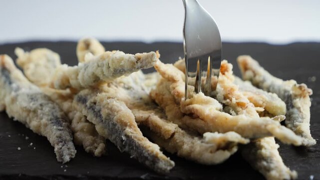 Close-up of fresh European anchovies, also known as boquerones, a popular small fish in Spain. Traditional Spanish tapas featuring fresh anchovies and Mediterranean seafood. High quality 4k footage