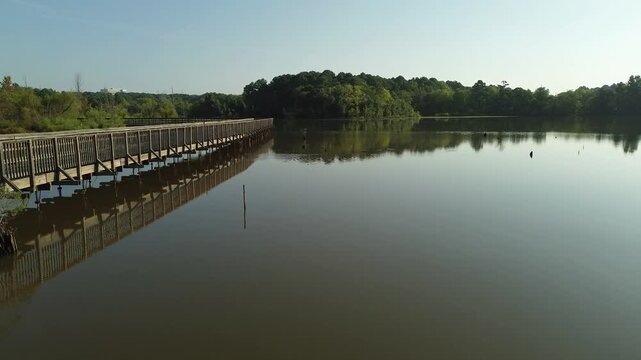 Low POV aerial shot of  Crabtree Creek and elevated walkway along the Raleigh greenway