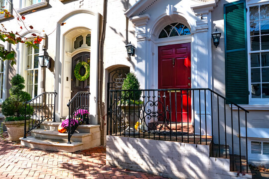 Red door with festive decoration. Cozy entrance to the house from the street.