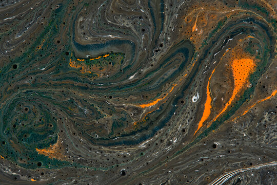 Abstract dark green and orange fluid art texture with organic swirling lines and tiny bubbles.