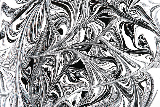 High contrast black and white liquid marbling texture with complex flowing wave lines background.