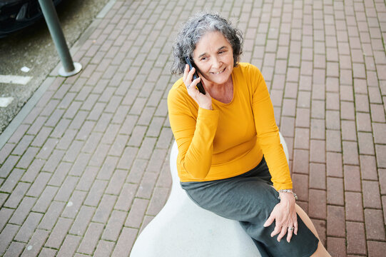 Senior woman smiling talking on cellphone outdoors