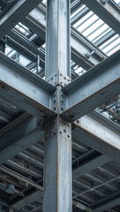 Obraz premium Heavy industrial steel frame construction with bolted girders and metal columns supporting modern warehouse ceiling.