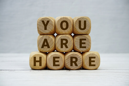 You Are Here alphabet letters on wooden background