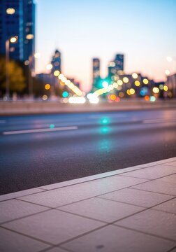 View of an empty urban road and sidewalk pavement at dusk, featuring a soft bokeh background of city architecture and glowing street lights, lights, modern, defocused