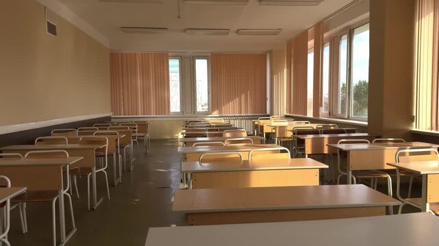 Empty classroom with wooden desks and chairs in school or university, educational background.