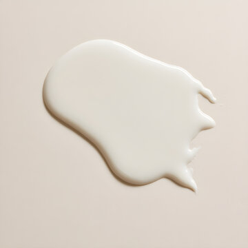 A flat lay photo of a hydrating facial moisturizer essence with a drop of ceramide milk essence, viewed from the top, showcasing a minimalistic skin care product background