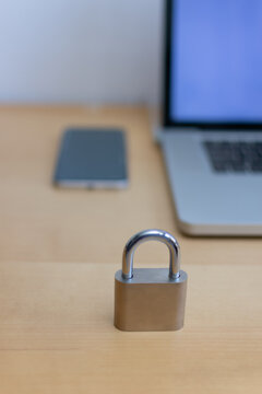Vertical front view of padlock with smartphone and laptop
