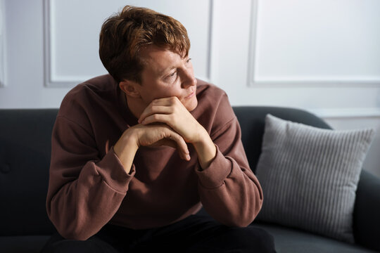 Frustrated man suffering from stress on sofa at home