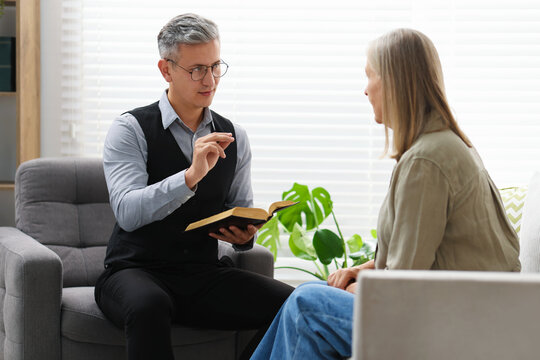 Pastor conducting Bible study with senior woman at home