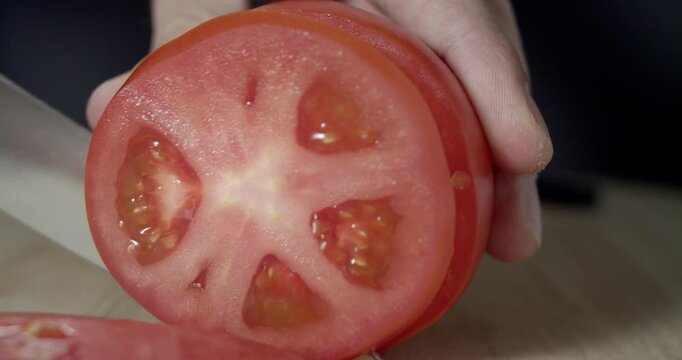 Macro wide close up of knife slicing and chopping a red tomato salad, food,