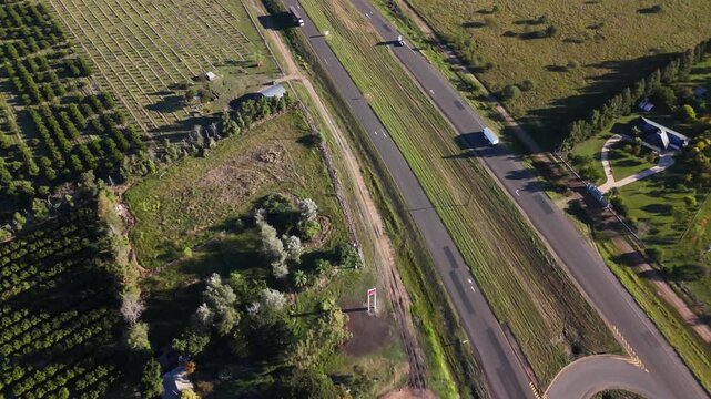 Top down aerial view of highway U-turn and fruit plantations in rural Argentina