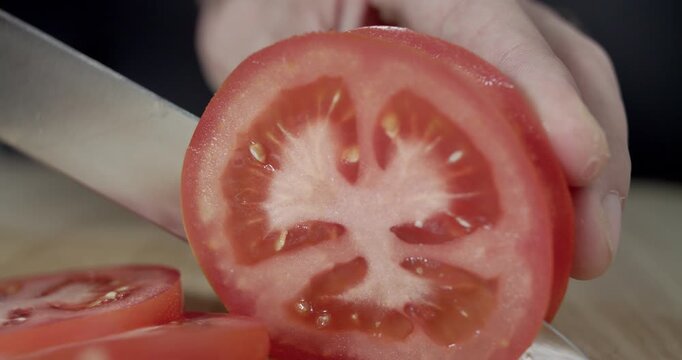 Macro wide close up of knife slicing and chopping a red tomato salad, food,