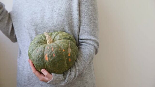 Autumnal moments mood. Unrecognizable woman holding two green autumn fall pumpkin in hands isolated on white background. Change of seasons ripe organic food concept, Halloween party Thanksgiving day