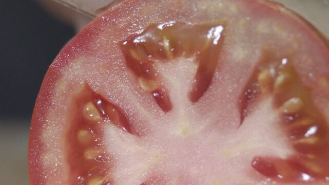 Macro wide close up of knife slicing and chopping a red tomato salad, food,