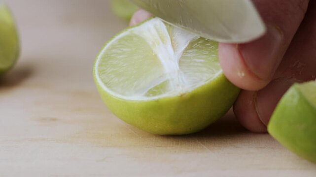Macro lemon being sliced and dropped slow motion knife lime cutting