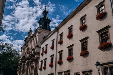 Fototapeta premium Historic building facade with red flowers in Krakow, Poland