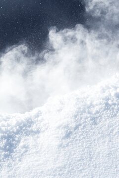 White powder snow cloud against dark sky winter