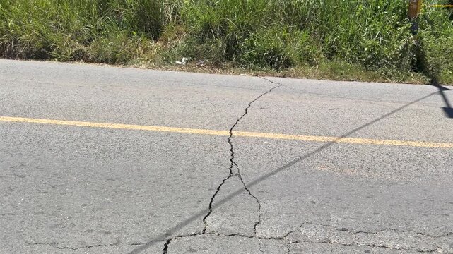 large crack splitting asphalt road surface after earthquake or ground movement