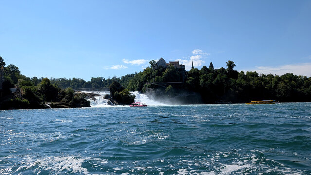 Rhine Falls with Schloss Laufen and sightseeing boats in Switzerland. 