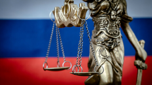 Golden scales balance beside Russian flag