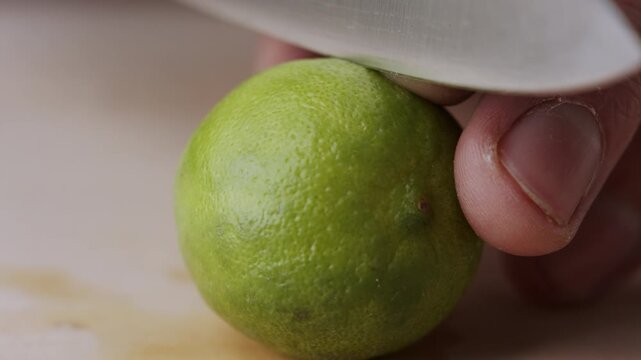 Macro lemon being sliced and dropped slow motion knife lime cutting