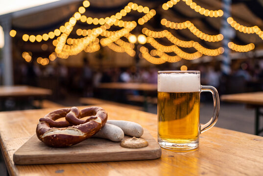 Golden Beer Stein with Pretzel and Bavarian Sausages on Wooden Table