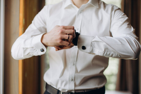 Groom adjusting cufflinks on wedding day