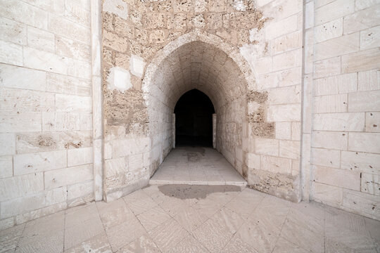 Detailed view of a pointed stone arch leading into a dark vaulted corridor within ancient Al-Muwaylih Fort in Tabuk