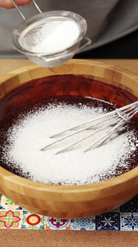 Male hands sift flour into melted chocolate for muffins. Chocolate muffins get smooth batter, rich flavour and moist crumb. Chocolate muffins bring homemade comfort to breakfast, coffee or lunchbox.