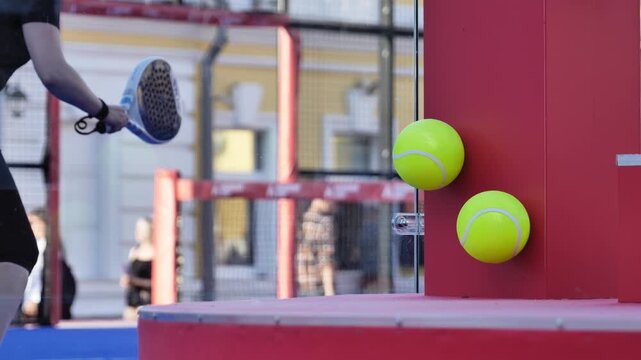 Female padel player hitting ball on court, enjoying competitive sports game