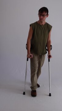 homem paciente em recupera&ccedil;&atilde;o andando com apoio de muletas 