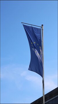 Waving flag from European Union on blue sky background shows Europe represented European Union flag as vertical video. The European Union banner as vertical video shows European alliance in trade.