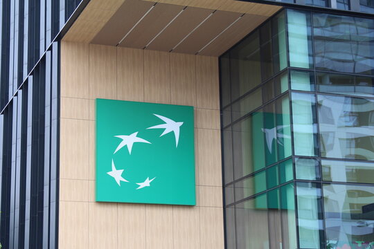 Warsaw, Poland, May 15, 2026. Logo sign of BNP Paribas bank mounted on modern building stone wall near glass entrance. High quality photograph