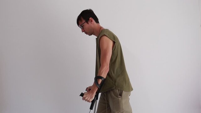 homem paciente em recupera&ccedil;&atilde;o andando com apoio de muletas 